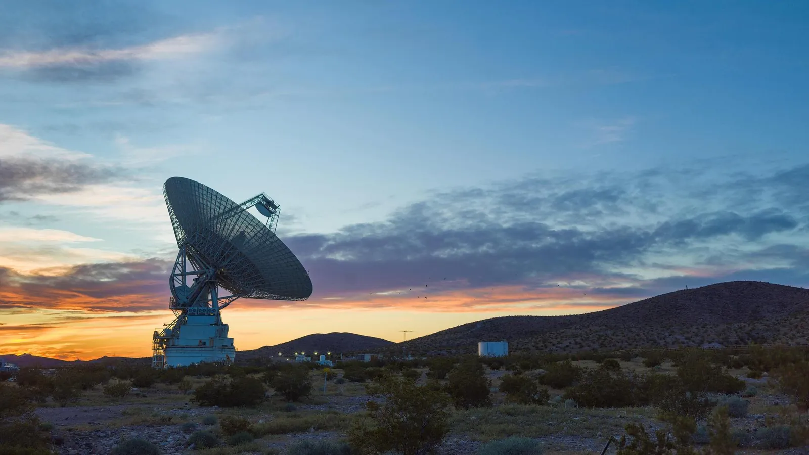 The 70-meter DSS-14 antenna at Goldstone silhouetted against a desert sunset in California