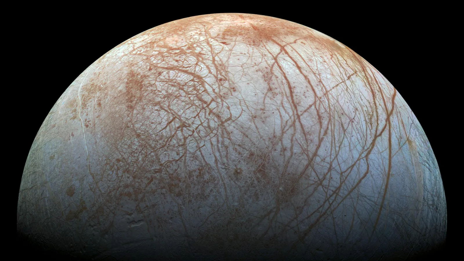 Europa imaged by the Galileo spacecraft, its icy surface laced with reddish-brown cracks