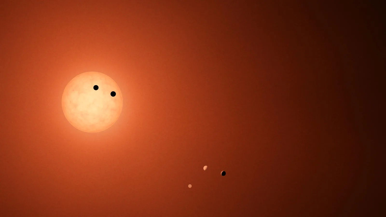 Artist concept of the TRAPPIST-1 system, with several planets transiting a red dwarf star